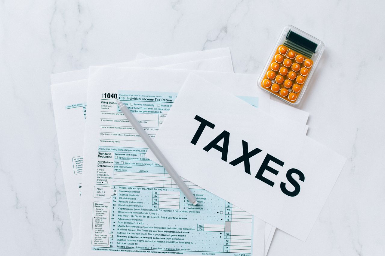 Mastering the First Impression: Your intriguing post title goes here Top view of tax forms, a calculator, and pen for tax preparation.